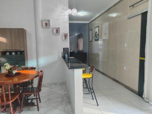 uma cozinha e sala de jantar com mesa e cadeiras em Casa confortável com piscina compartilhada em Aracaju