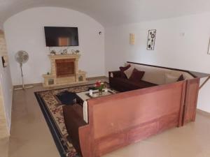 ein Wohnzimmer mit einem Sofa und einem Kamin in der Unterkunft magnifique villa avec piscine in Dawwār al Frinine