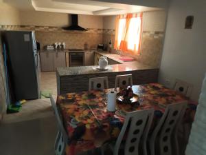 eine Küche mit einem Tisch und Stühlen sowie eine Küche mit einer Theke in der Unterkunft magnifique villa avec piscine in Dawwār al Frinine