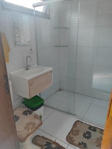 y baño con lavabo y ducha. en Casa confortável com piscina compartilhada en Aracaju