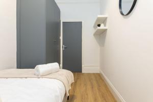 Free Parking | Free Wifi | Smart TV في Sketty: غرفة نوم مع سرير ومرآة على الحائط