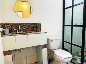 La salle de bains est pourvue de toilettes, d'un lavabo et d'un miroir. dans l'établissement La casa del Río Las luciérnagas By Rotamundos, 
