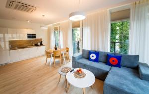 Una sala de estar con un sofá azul y una mesa. en Wyspa Uznam Sea Side Garden Resort Promenada, en Świnoujście