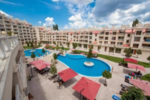 an apartment complex with a swimming pool and red umbrellas at Seaside View Apartment in Varna in Varna City