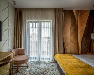 a hotel room with a bed and a window at Hotel Branco Timisoara in Timişoara