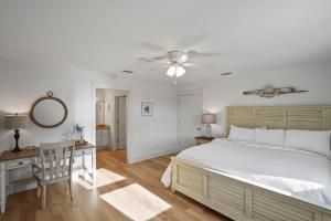une chambre avec un lit, un bureau et un ventilateur de plafond dans l'établissement Southern Mermaid Cottage- Pet Friendly Fenced, à Saint Joe Beach