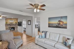 un salon avec un canapé et un ventilateur de plafond dans l'établissement Southern Mermaid Cottage- Pet Friendly Fenced, à Saint Joe Beach