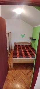 um pequeno quarto com uma cama num quarto em Čardak em Kneževac