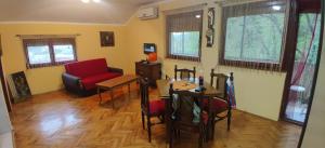 uma sala de estar com uma mesa e uma cadeira em Čardak em Kneževac