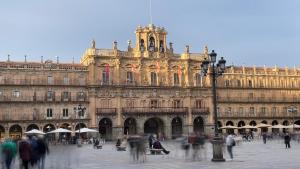 a large building with people walking in front of it at Plaza Mayor de Salamanca By LixLoft in Salamanca