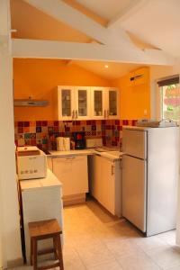 a kitchen with orange walls and a refrigerator at Gîte proche de Giverny in Saint-Aquilin-de-Pacy