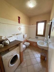 y baño con lavadora y lavamanos. en Agriturismo Podere le Tombe en Palaia