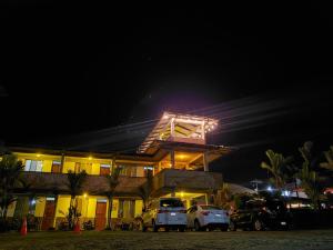 uma casa com carros estacionados em frente a ela à noite em San Bosco Inn em La Fortuna