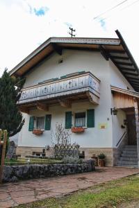 Casa blanca con ventanas verdes y balcón. en Ferienwohnung Karwendelblick, en Mittenwald