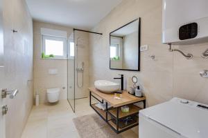 uma casa de banho com um lavatório, um WC e um chuveiro em Villa Corcovado II em Vodice