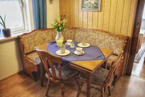 a dining room table and a couch with a vase on it at Ferienwohnung Karwendelblick in Mittenwald +13 photos