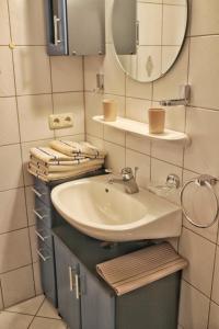 y baño con lavabo, espejo y toallas. en Ferienwohnung Karwendelblick, en Mittenwald