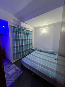 um quarto com uma cama com uma luz azul em Departamento completo en edificio Camilo Recalde 477 em Ciudad del Este