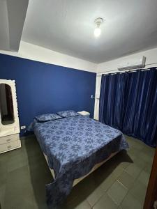 um quarto azul com uma cama e uma televisão em Departamento completo en edificio Camilo Recalde 477 em Ciudad del Este