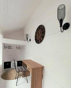 a room with a wooden table and a clock on the wall at B&L Chic apartment in Škaljari