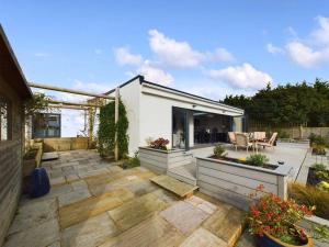 un jardín con patio y una casa en Luxe Bungalow w/ Hot tub, pool table & more, en Findon