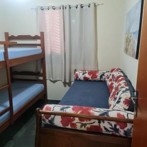 a small bedroom with a bed and a bunk bed at Apartamento Praia das Toninhas in Ubatuba