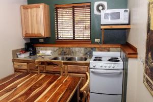 a kitchen with a white stove and a microwave at Timber Creek Chalets- 6 chalet in Estes Park