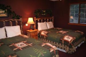 a bedroom with two beds and a lamp on a table at Timber Creek Chalets- 6 chalet in Estes Park