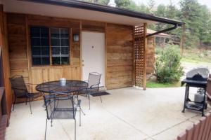 a patio with a table and chairs in front of a cabin at Timber Creek Chalets- 6 chalet in Estes Park