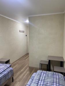 um quarto com duas camas e duas mesas em Нарэл em Bishkek