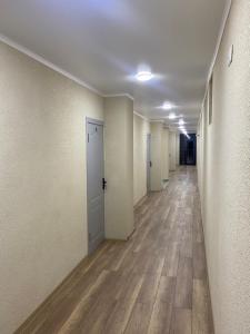 an empty hallway with white walls and wooden floors at Нарэл in Bishkek