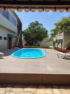 a swimming pool in the middle of a patio at Casa confortável com piscina compartilhada in Aracaju