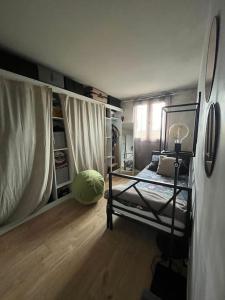 ein Schlafzimmer mit einem Bett in einem Zimmer mit Holzböden in der Unterkunft Cosy appartement - Evry in Évry-les-Châteaux