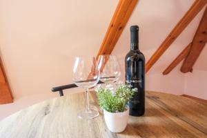 a bottle of wine and two wine glasses on a table at Apartman Maja in Jajce +5 photos