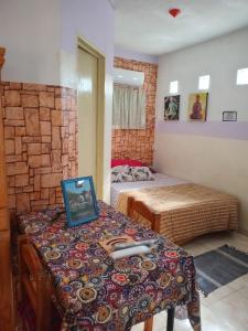 a bedroom with two beds and a table with a picture on it at DORMI-con HIDROMASAJE- POSADA RUTA 22 totalmente EQUIPADO in Plottier