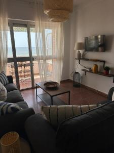 a living room with a couch and a view of the ocean at Alta Vista Punta Umbría in Punta Umbría