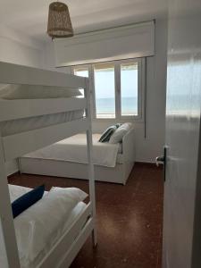 a bedroom with two bunk beds and a window at Alta Vista Punta Umbría in Punta Umbría
