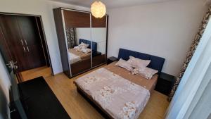Dormitorio pequeño con cama y espejo en MMT SweetHome 2 en Ploieşti