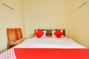 a bedroom with a large bed with red pillows at OYO St Residency in Madukkarai