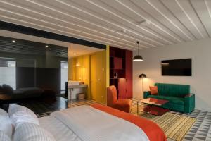 1 dormitorio con 1 cama y sala de estar en Manifest Restaurant and Hotel Gyumri, en Gyumri