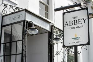 una señal para la casa de la abadía en un edificio en The Abbey Town House - Cheltenham, en Cheltenham