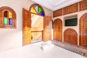 1 dormitorio con 1 cama, ventana y TV en 16 Riads en Marrakech