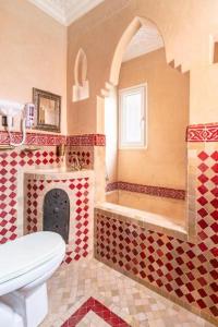 a bathroom with a toilet and a sink and a fireplace at 16 Riads in Marrakech