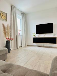 sala de estar con TV de pantalla plana en la pared en Modern Wohnen mit SmartTV, Arbeitsplatz und Küche, en Bad Oeynhausen