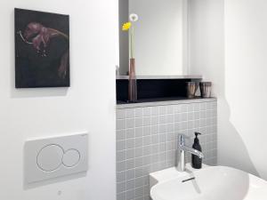 W białej łazience znajduje się umywalka i lustro. w obiekcie Zehuus Gartenstudio mit Terrasse w Kolonii