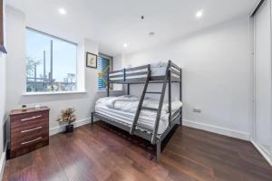 ein Schlafzimmer mit einem Etagenbett und einem Fenster in der Unterkunft New Apartment 20 mins from London Waterloo BP65 in London