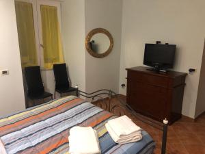 een slaapkamer met een bed en een tv op een dressoir bij Casa Vittoria in Portici