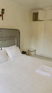 a bedroom with a large white bed with a gray headboard at Villa Quartet Retreat in Nairobi