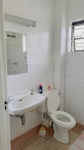 a white bathroom with a toilet and a sink at Villa Quartet Retreat in Nairobi