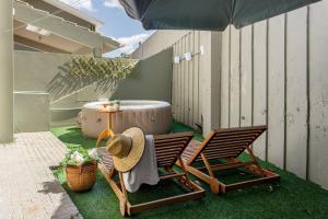 佛羅安那波里的住宿－Casa da Mole Praia Particular Churrasco wifi 250mb，庭院设有两把椅子、一张桌子和一个浴缸。